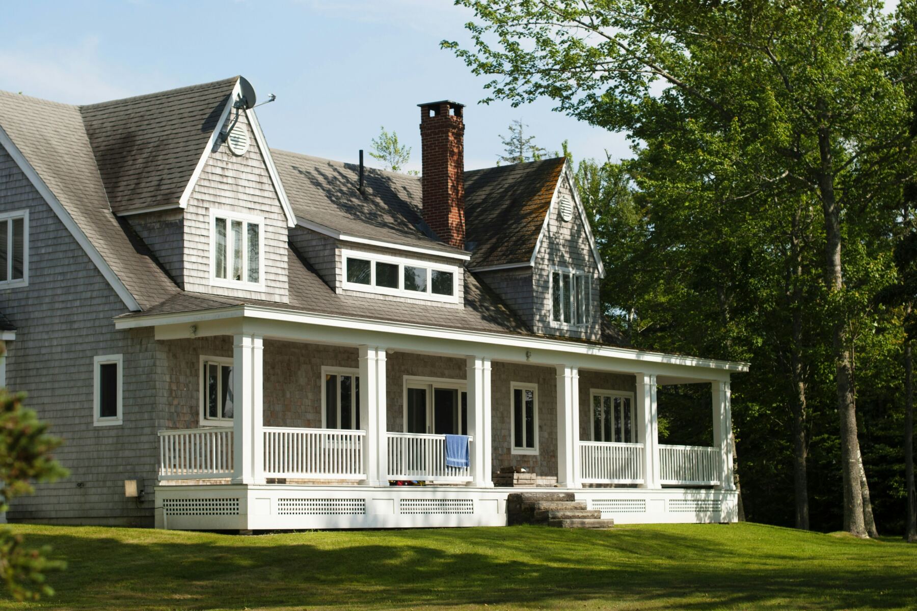 Gray shingled home with a wide white front porch