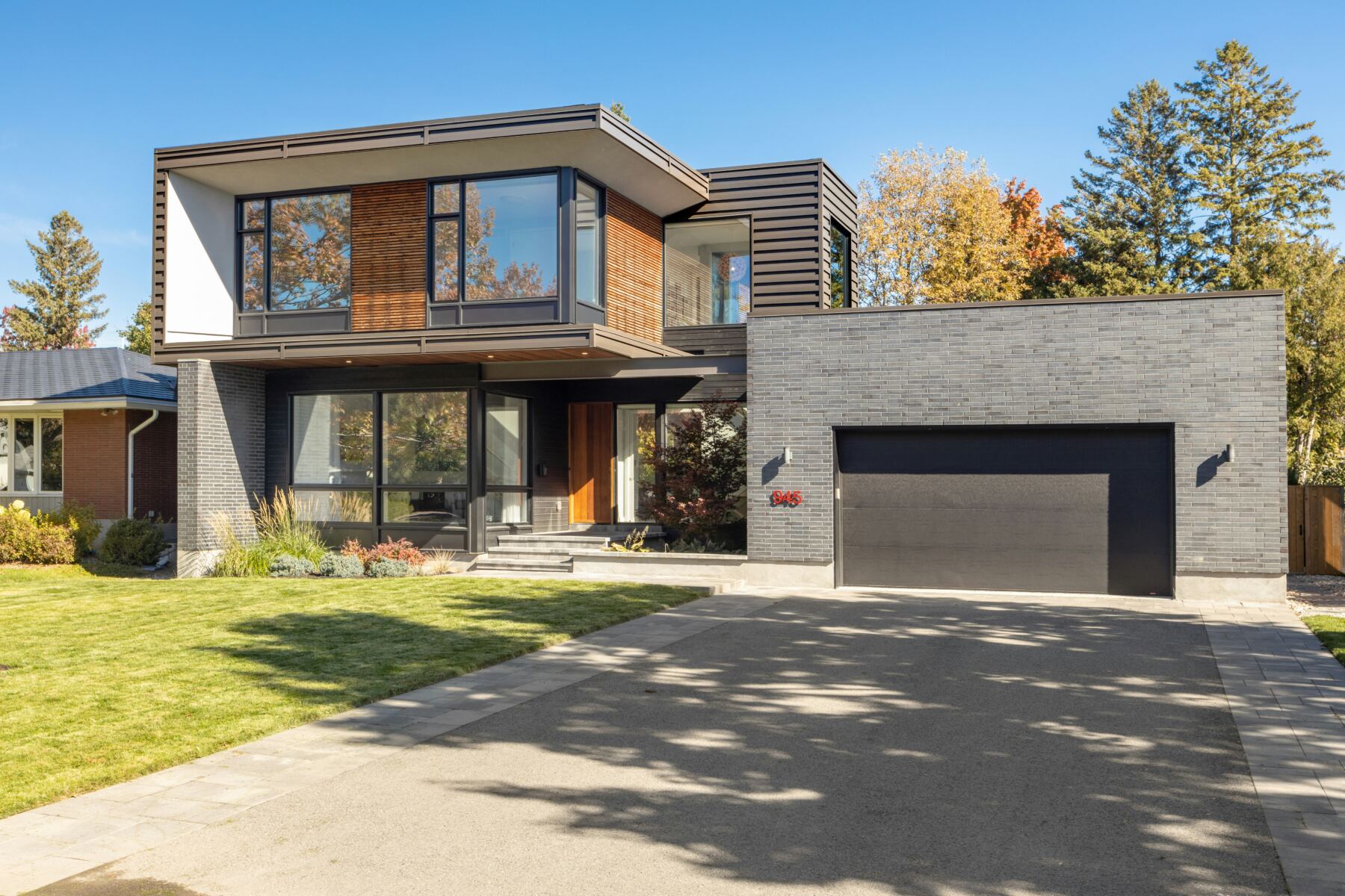 Modern two-story home with large windows and a landscaped front yard