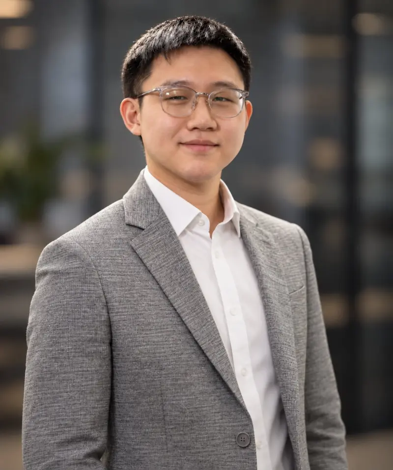 Portrait of Daniel Park, REALTOR®, in a gray blazer in a modern office