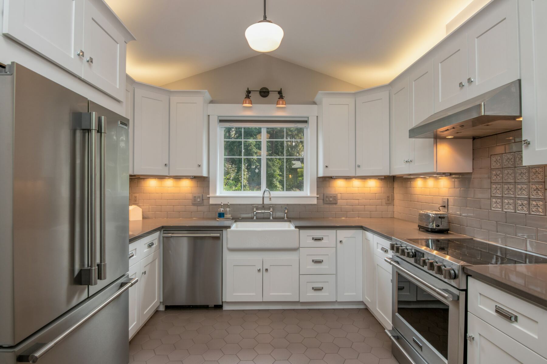 Bright white kitchen with a farmhouse sink and pendant light