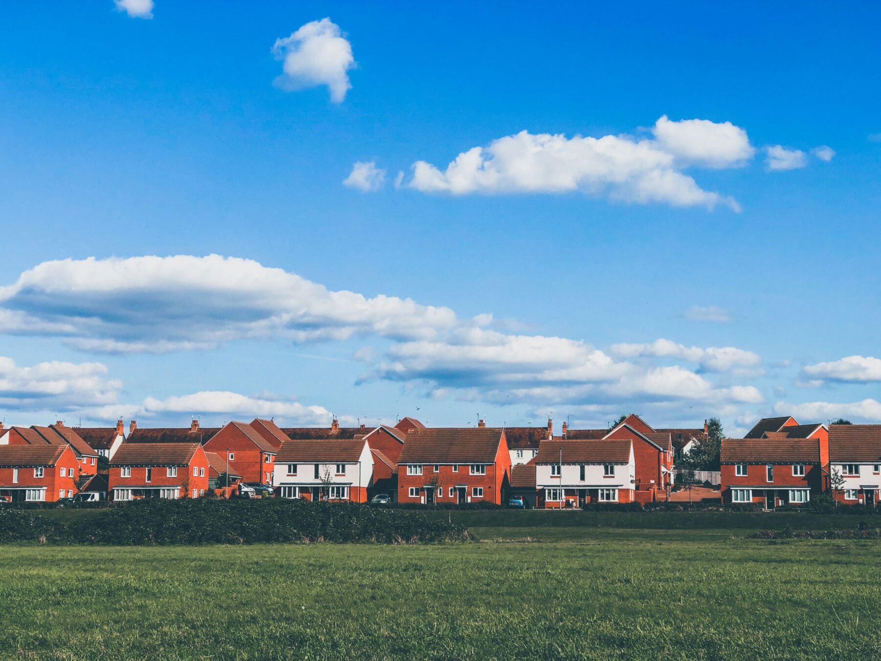 Row of brick townhomes beneath a blue sky
