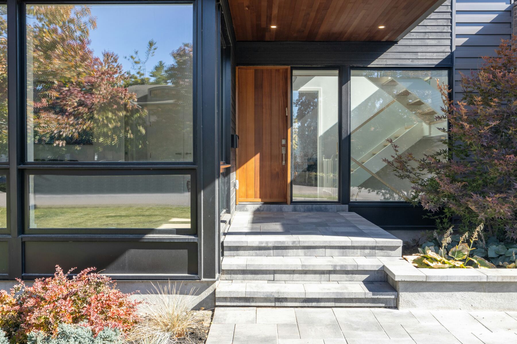 Contemporary home entrance with wood door and stone steps