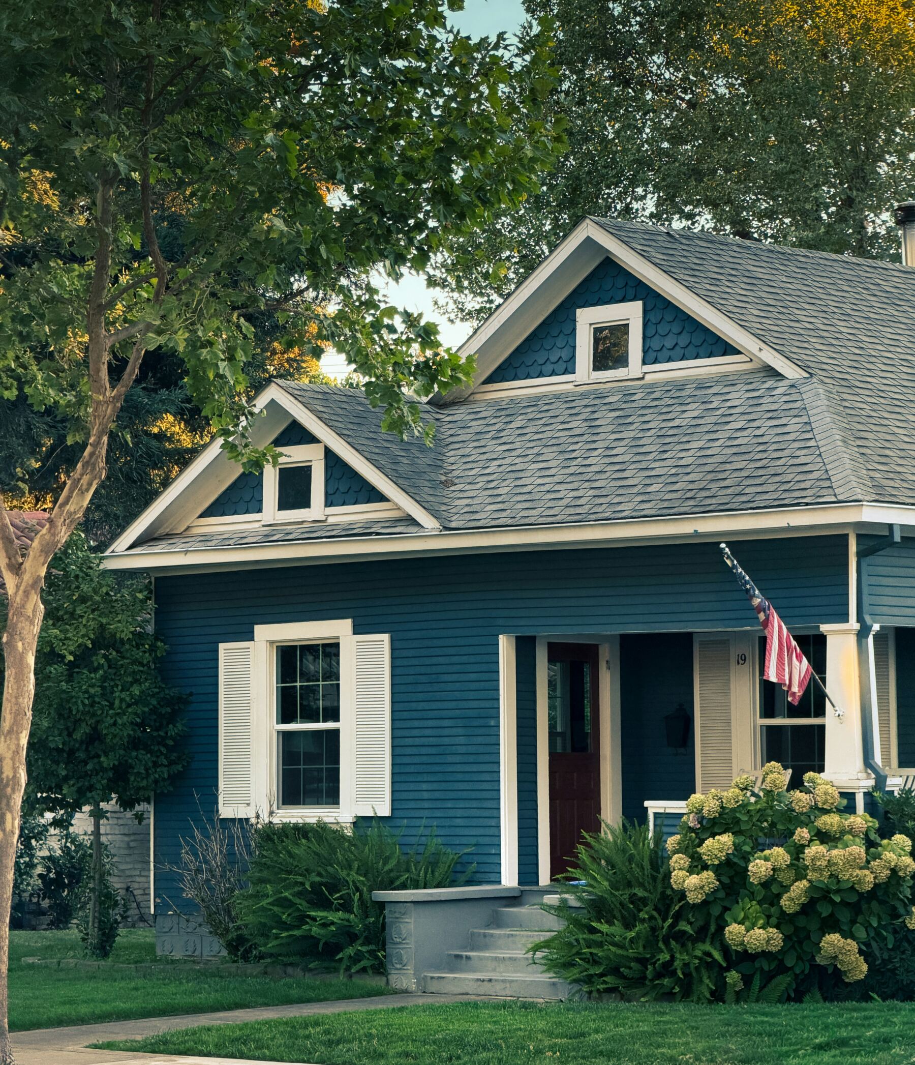Blue craftsman-style home with a front porch and garden